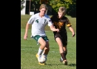 LANDON COOLEY (#7) clears the ball away from the attacking Ogemaw Heights player in during last week’s MHSAA District loss to the Falcons.