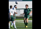 LUKE COGGINS (#2, right) heads the ball away from the Clare players in last Wednesday’s 4-0 loss to the Pioneers. --Journal Photo