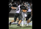 RILEY HILL (#58, right) wraps up the Clare runner in Friday’s 0-55 Spartan loss. Hill once again led the defense with 4 tackles on the night. --Journal Photo