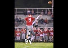 ZACH LAURES (#15) gets a pass away under pressure from the Tawas Braves in Thursday’s season opener. --Journal Photo